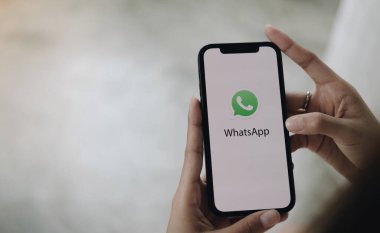 CHIANG MAI, THAILAND - LAN 10 2022: bir adam iPhone tutuyor ve açık apstore arama sosyal internet hizmeti WhatsApp ekranda. iPhone Apple tarafından oluşturuldu ve geliştirildi.