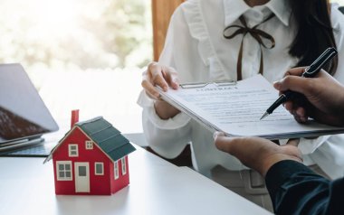Emlakçı ev tasarımını ve satın alma anlaşmasını görmeye gelen müşterilere ev tarzını anlatıyor. Modern bir ofisin içinde