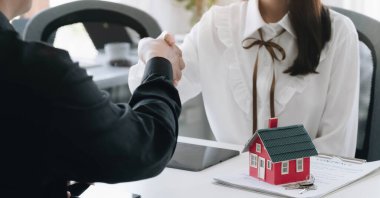 Başarılı bir anlaşma, gayrimenkul, ev satın alma sözleşmesi konsepti, ofis sözleşmesi imzalandıktan sonra banka çalışanlarıyla el sıkışan alıcı.