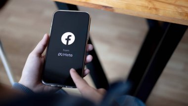 CHIANG MAI, THAILAND MAR 18 2022: Ekranda sosyal internet servis Facebook ile iPhone Pro Mix 'i tutan kadın