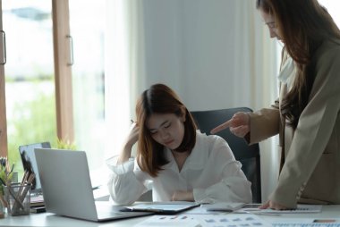 Finansal rapordaki rakamları anlamaya çalışan hoşnutsuz bir yönetici. Meslektaşına baktı, ona kızgındı, açıklayamıyordu. Yorgun ve stresli görün.