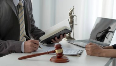 İş kadını ve avukatlar, ofisindeki ahşap masada pirinç tartı ile sözleşme belgelerini tartışıyorlar. Hukuk, hukuk hizmetleri, tavsiye, Adalet kavramı