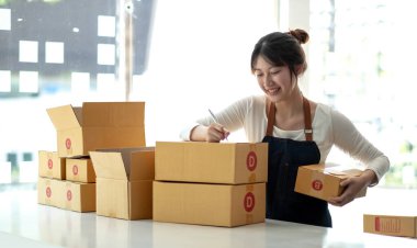 Küçük işletmeler kurma portresi KOBİ sahipleri fatura kutusu üzerinde çalışan kadın girişimciler ve kutuları paketlemek, müşterilere satmak, KOBİ iş fikirlerini çevrimiçi olarak satmak için İnternet üzerinden siparişleri kontrol ediyorlar