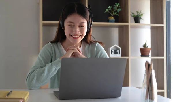 Smart Asian students find satisfaction while studying online on the Internet and meeting with friends to search for information on their laptops at home