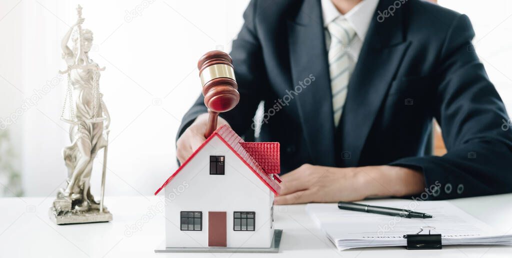 Businessman hand hold old wood Judge hammer with Mini wood house model from model on wood table, Planning buy Real Estate, Planning to buy property and Choose the best, financial liabilities concept