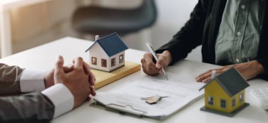 Real estate agents explain the document for customers who come to contact to buy a house, buy or sell real estate concep