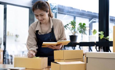 Asyalı kadın pano yazıyor, ev teslimatı, KOBİ-ticaret konsepti, ev işi, teslimat onayı.