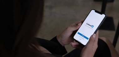 CHIANG MAI, THAILAND, HAZİRAN 1 HAZİRAN 2022: Bir kadın ekranda LinkedIn uygulaması ile Apple iPhone X tutuyor. LinkedIn akıllı telefonlar için fotoğraf paylaşım uygulaması