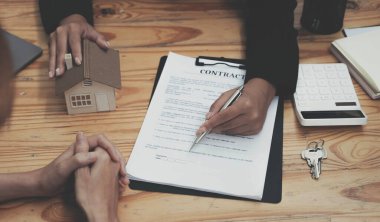 Emlakçı ev satın alma anlaşmasının şartları hakkında konuştu ve müşteriden sözleşmeyi yasal hale getirmek için belgeleri imzalamasını istedi, ev satışları ve ev sigortası kavramı