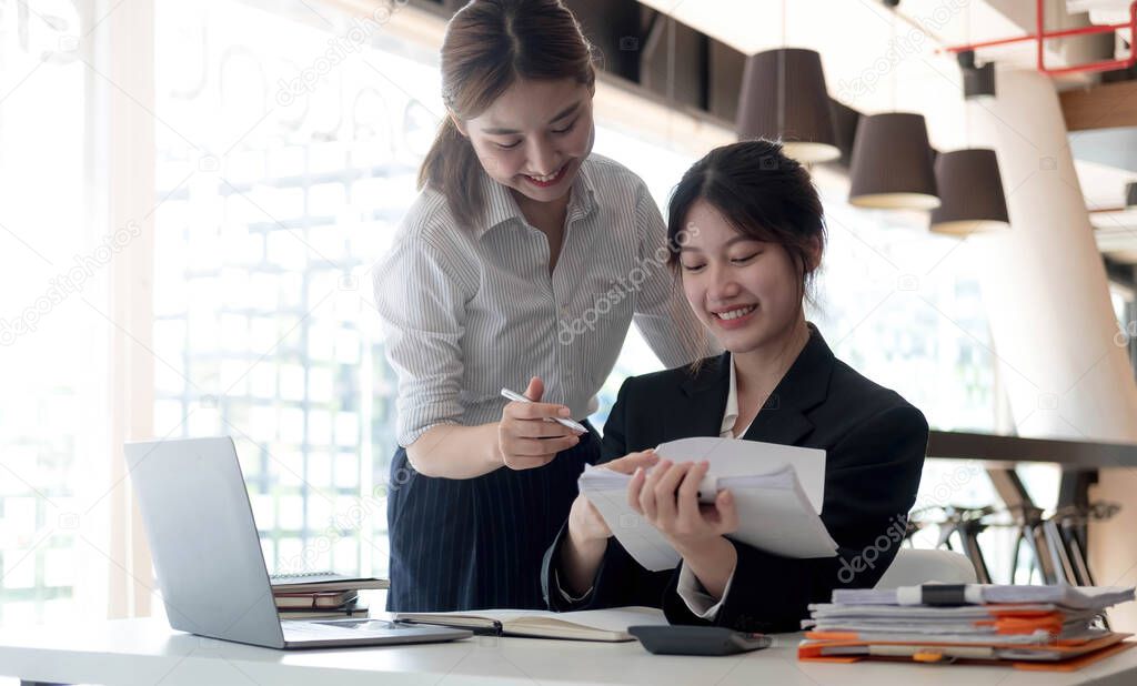 Two young asia business woman working together in office space.