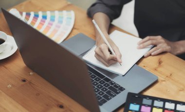 Stüdyoda ya da ofiste bilgisayarla çalışırken grafik tableti kullanan genç Asyalı kadın tasarımcı
