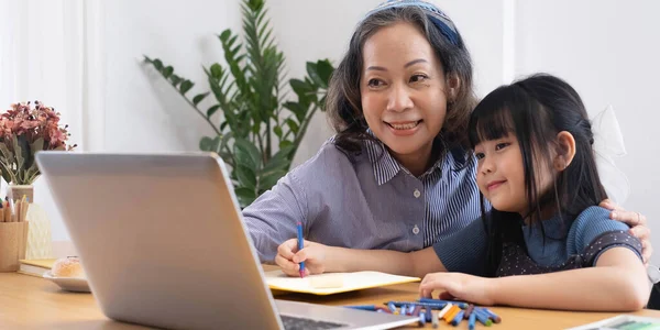 Asiatisk Barnmorska Lär Barnbarn Att Teckna Och Göra Läxor Hemma — Stockfoto