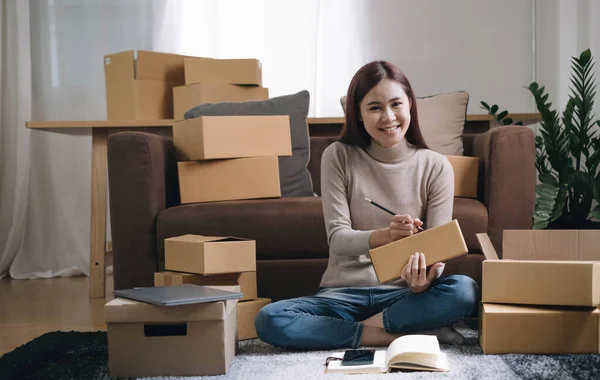 Portrait of Starting small businesses SME owners female entrepreneurs working on receipt box and check online orders to prepare to pack the boxes, sell to customers, sme business ideas online