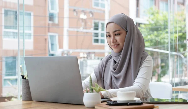 Asian Muslim business woman in hijab headscarf working with computer laptop in the modern office. business people, diversity and office concep