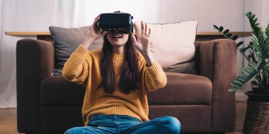 Asyalı kadın evde eğlenmek için video oyunu oynuyor, Asyalı kadın tatilde evde neşeli. Mutlu kadın metaverse VR teknoloji konsepti oynuyor