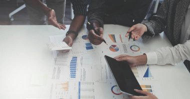 İş dünyası ekibi harita, kontrol ve analizlerle beyin fırtınası yapıyor.