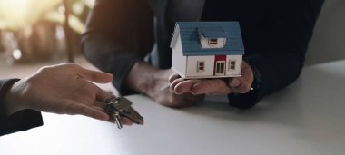 Emlak ve anlaşma konsepti satın almak. Emlakçılar bir ev almayı ve ajanslarındaki müşterilere anahtarları vermeyi kabul ettiler.
