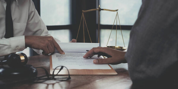 Бизнес и юристы обсуждают контрактные документы с медными весами на столе в офисе. Право, юридические услуги, консультации, правосудие и правовая концепция с эффектом пленки зерна