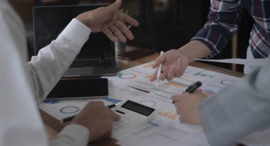 İş arkadaşları mali veriler ve pazarlama büyüme raporu grafiği ile analizi tartışıyor, Konuşan Beyin Fırtınası İletişim Uzmanıyla Görüşüyor