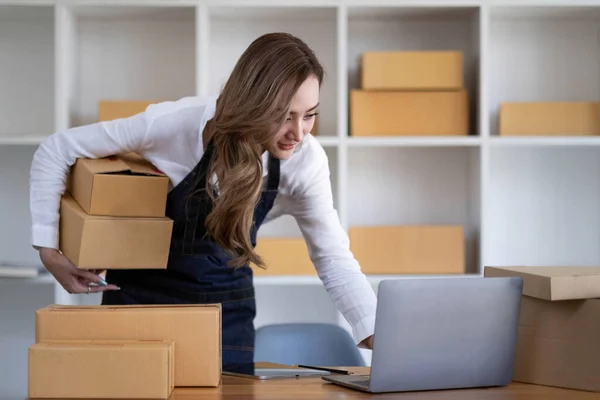 Portrait of Starting small businesses SME owners female entrepreneurs working on receipt box and check online orders to prepare to pack the boxes, sell to customers, SME business ideas online