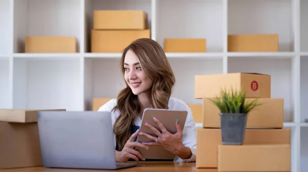 Portrait of Starting small businesses SME owners female entrepreneurs working on receipt box and check online orders to prepare to pack the boxes, sell to customers, sme business ideas online