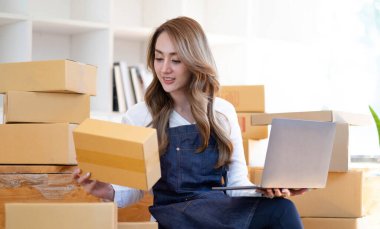 Küçük bir işletme kuran KOBİ sahibi ve kadın girişimciler, halatı, ürünleri paketlemek için kutuları bağlamak ve çevrimiçi olarak müşterilere satılacak bir kutu mal hazırlamak için kullanıyorlar.