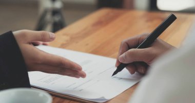 Çekici Asyalı genç bayan emlakçı ya da emlakçı müşterisiyle ofisinde buluşuyor. Ev kiralama danışmanı