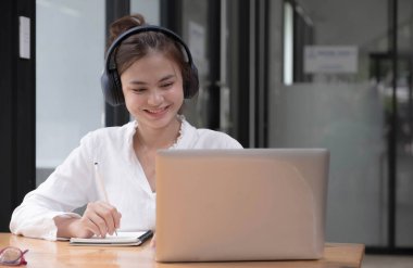 Öğrenci öğrenme çevrimiçi dersini laptoplu bilgisayar kullanarak ve iş yerinde not defteri yazarak kapat, E öğrenme ve çevrimiçi çalışma konsepti