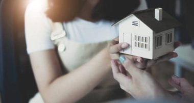 Closeup real estate agent to buy house and land are delivering house to customer after agreeing to make a home purchase agreement