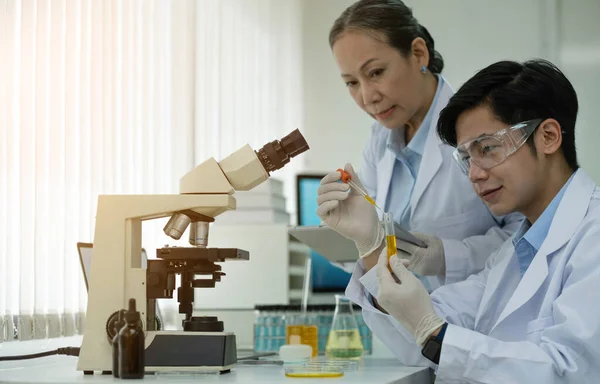 Asian scientists work in hospital pharmacology science research lab. Woman medical scientist and researchers teamwork analyzing innovative virus protective vaccines in health care biology laborator