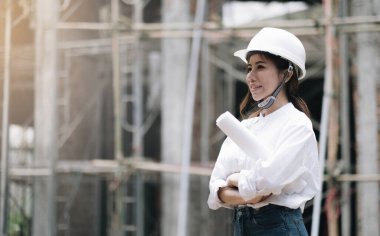 Female construction engineer. Architect with a tablet computer at a construction site. Young Woman looking, building site place on background. Construction concep