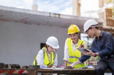 Female construction engineer. Architect with a tablet computer at a construction site. Young Woman looking, building site place on background. Construction concep