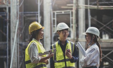 Professional Construction and Engineer team Working on workplace. Professional black architect and construction worker working look at blueprint plan on site