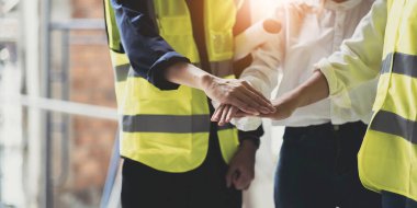 Businessmen and engineers join hands to build successful projects. Teamwork concept