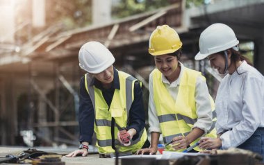Three experts inspect commercial building construction sites, industrial buildings real estate projects with civil engineers, investors use laptops in background home, concrete formwork framing