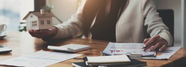 Ev modelinde finansman yapan ve emlak yatırımının maliyetini hesaplayan bir iş kadını ve diğer bir deyişle vergi sistemi. İş Finansmanı Muhasebe Bankacılık Konsepti