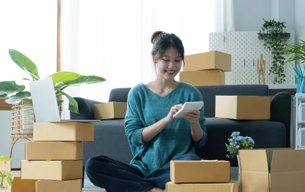 Business woman start up small business entrepreneur SME success .freelance woman working at home with Online Parcel delivery. SME and packaging deliveryconcep
