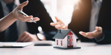 Real estate broker agent presenting and consult to customer to decision making sign insurance form agreement, buy and sell home model, concerning mortgage loan offer for and house insuranc