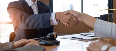 Businessman shaking hands to seal a deal with his partner lawyers or attorneys discussing a contract agreement clipart