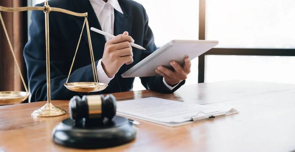 Law and Legal services concept, Good service cooperation, lawyer hands using tablet and working on wood table office.