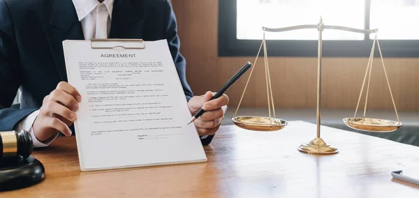 Male lawyer working with contract papers and wooden gavel on tabel in courtroom. justice and law ,attorney, court judge, concept