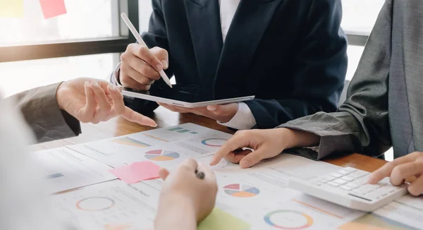 Teamwork with business people analysis cost graph on desk at meeting room