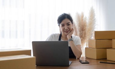 Küçük işletme girişimciliğine başlamak, ev ofisinde çalışan Portre genç kadın, BOX, akıllı telefon, dizüstü bilgisayar, çevrimiçi, pazarlama, ambalaj, dağıtım, KME, e-ticaret konsepti