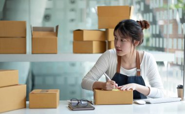 Küçük işletme sahipleri iş yerinde bilgisayar ve telefon kullanıyorlar, satıcılar üretim siparişlerini kontrol ediyorlar. Ürünleri müşterilere yollamak, nakliye fikirleri satmak için paketleyin