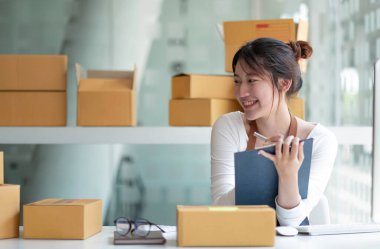 Küçük işletmeler kuran KOBİ 'li kadın girişimciler, kutuların hazırlanması, müşterilere satılması, KOBİ' nin çevrimiçi iş fikirlerinin hazırlanması ve incelenmesi için bir dizüstü bilgisayar veya defter kullanıyorlar.