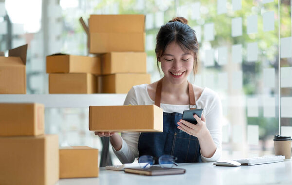 Startup small business entrepreneur SME, asian woman receive order on phone. Portrait young Asian small business owner home office, online sell marketing delivery, SME e-commerce telemarketing concep