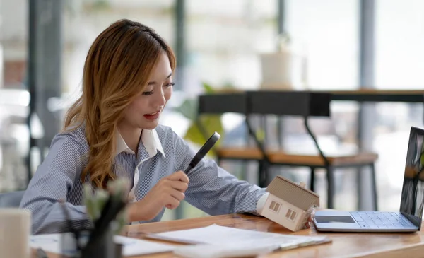 Close Businesswomen Holding Magnifying Glass Finding Wooden Shape House Realtor — Stock fotografie