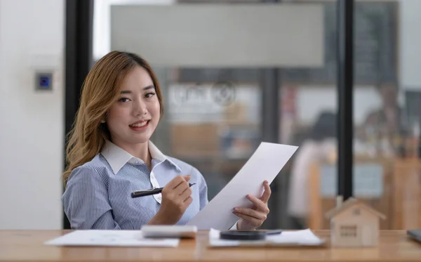 Portrait of smiling beautiful business asian woman with working in modern office desk using laptop computer, Business people employee freelance online marketing e-commerce telemarketing concept
