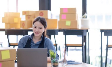 Portrait of Starting small businesses SME owners, Asian woman check online orders Selling products online and working with boxs freelance work at home Asian sme business online small medium enterpris