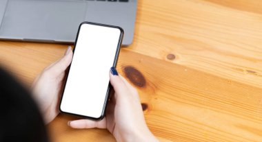 el kadını telefon kullanıyor, boş ekran akıllı telefon ve bilgisayar ahşap masa görünümünde..